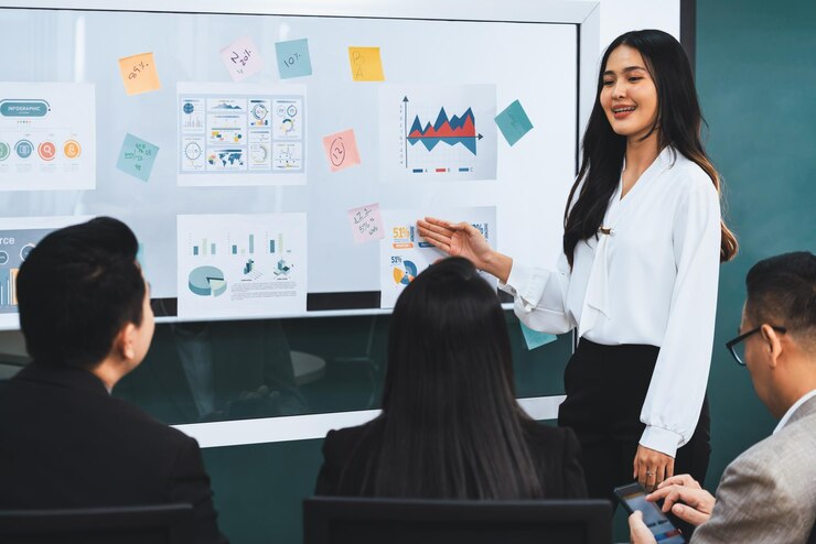 female-leader-presenting-growth-statistics-with-confident-front-whiteboard-rounded-by-executive-committee-listening-data-analyst-business-plan-conference-room-meeting-intellectual_31965-263506